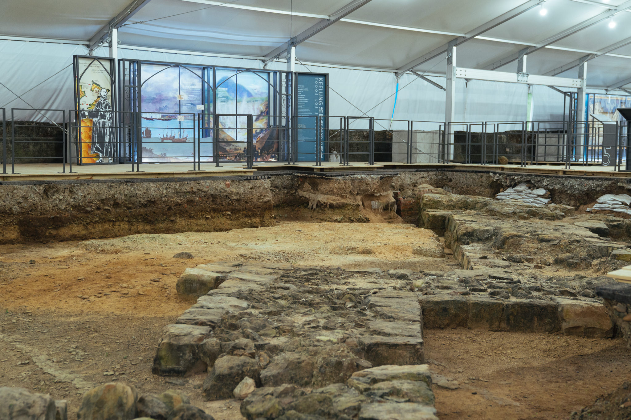 「西班牙諸聖教堂考古遺址展示」現場一隅，照片中可見出土的教堂基座遺跡
